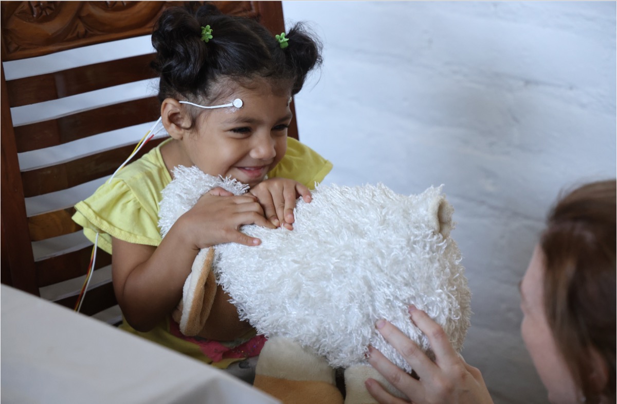 Young girl smiling during a neurofeedback session at ONUVA